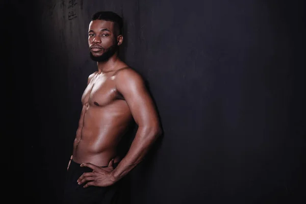 Beau torse nu musclé jeune homme afro-américain regardant caméra sur noir — Photo de stock