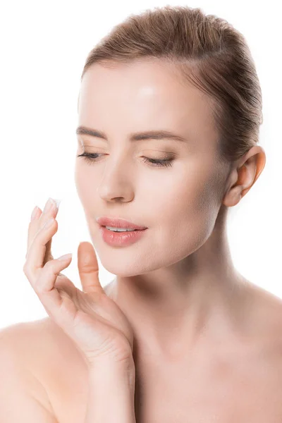 Ritratto di donna che applica crema su viso isolato su bianco — Foto stock