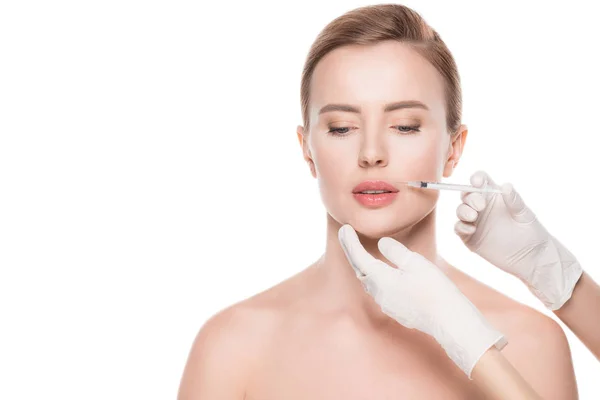 Mãos de esteticista que fazem a injeção em lábios de mulher isolados no branco — Fotografia de Stock