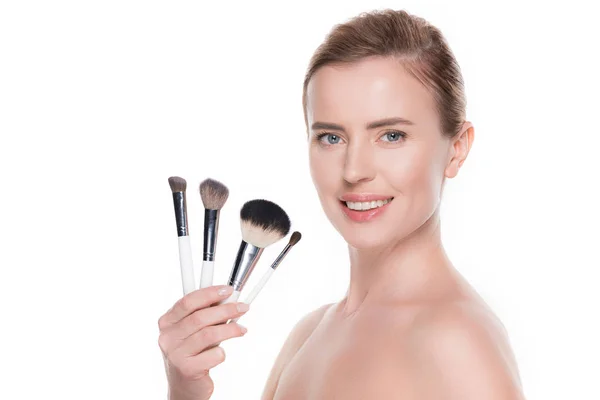 Mujer sonriente con cepillos cosméticos aislados en blanco - foto de stock