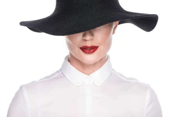 Mujer con la cara parcialmente oculta bajo el sombrero aislado en blanco - foto de stock