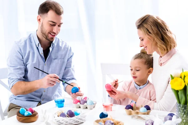 Familia para colorear huevos de Pascua con pinceles - foto de stock