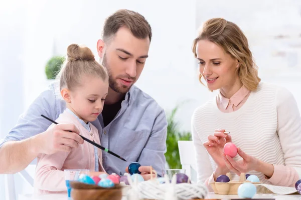 Bambino e genitori che colorano uova per Pasqua — Foto stock