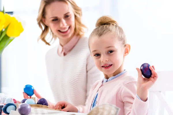 Child showing Easter egg by smiling mother — Stock Photo