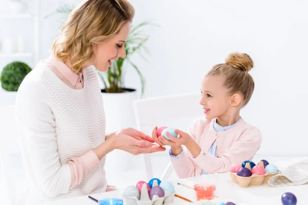 Kid girl giving mother Easter eggs — Stock Photo