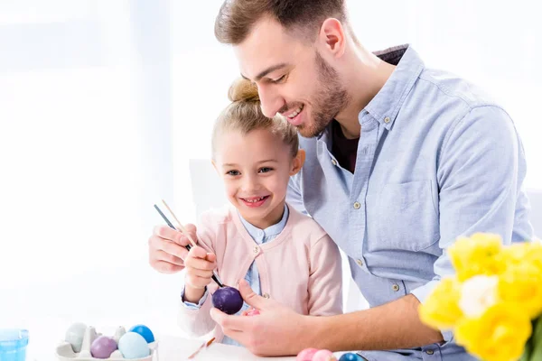 Pai ajudando filha a colorir ovos de Páscoa — Fotografia de Stock