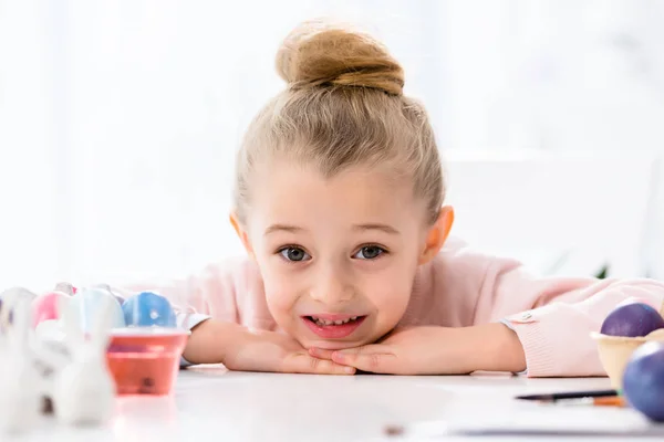 Cute child by the table with Easter eggs — Stock Photo