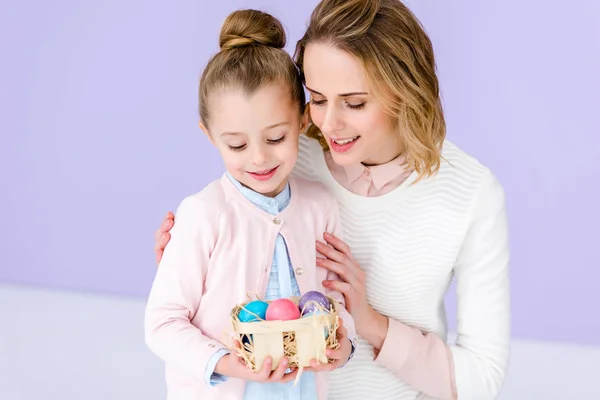 Blonde woman and child holding Easter eggs — Stock Photo