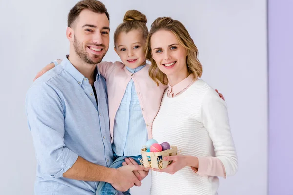 Cheerful family holding painted Easter eggs — Stock Photo