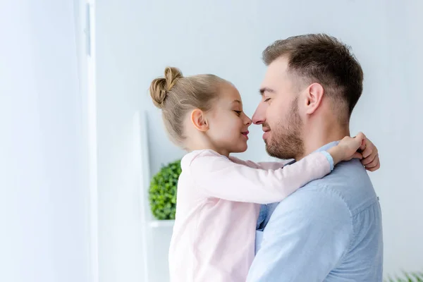 Pai e criança menina abraçando e tocando narizes — Fotografia de Stock