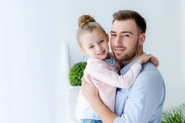 Sonriente padre abrazando linda hija - foto de stock