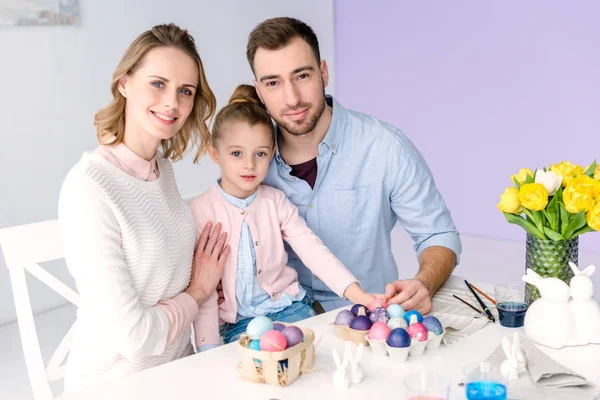 Niño y padres por mesa con huevos de Pascua - foto de stock