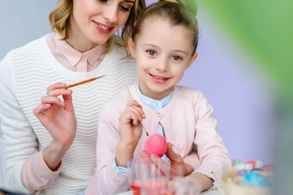 Madre e hija pintando huevos de Pascua - foto de stock