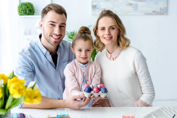 Cheerful family holding Easter painted eggs — Stock Photo