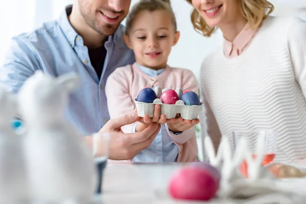 Família sorridente segurando ovos de Páscoa — Fotografia de Stock