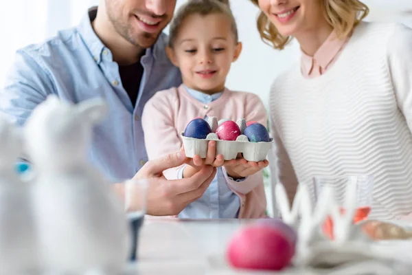 Smiling family holding Easter eggs — Stock Photo