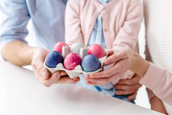 Œufs de Pâques en carton dans les mains de la famille avec fille — Photo de stock