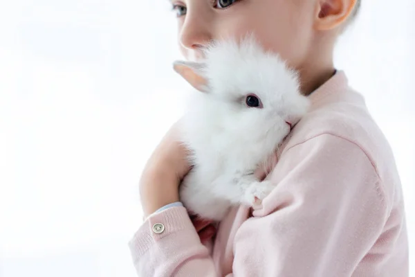 Adorable niño abrazando conejo blanco - foto de stock