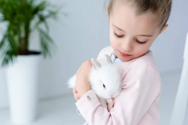 Menina criança segurando coelho branco — Fotografia de Stock