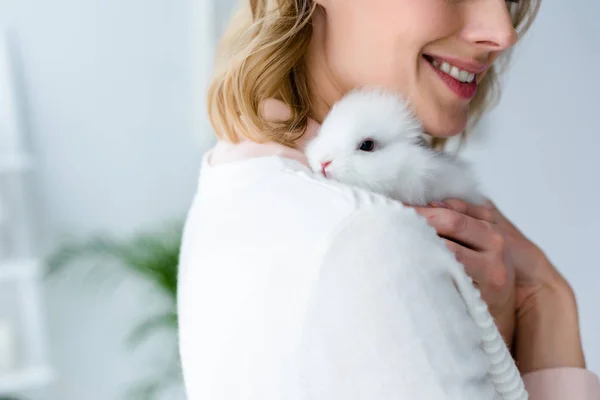 Mujer rubia abrazando conejo blanco - foto de stock