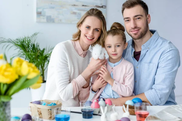 Famiglia che gioca con coniglietto pasquale da tavolo con uova colorate — Foto stock