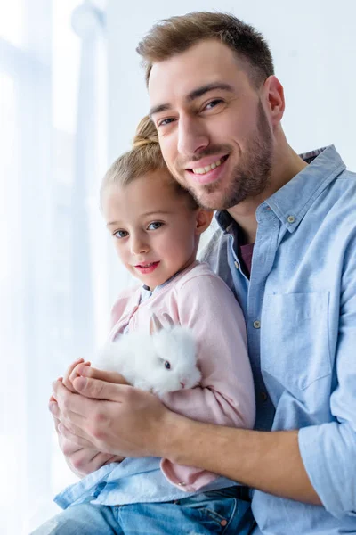 Pai e criança menina segurando coelho branco — Fotografia de Stock