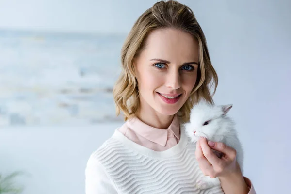 Femme blonde tenant lapin blanc — Photo de stock