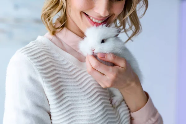 Mujer rubia abrazando conejito blanco - foto de stock