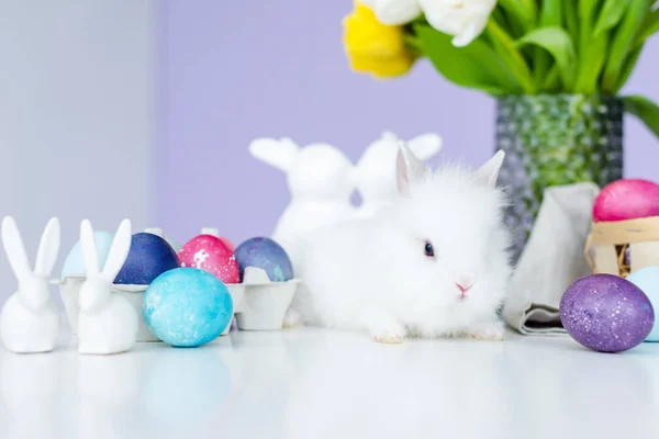 Bunny in nest on table by Easter eggs — Stock Photo