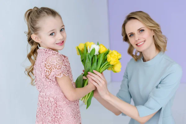 Mãe e filha segurando buquê de flores da primavera em 8 de março — Fotografia de Stock