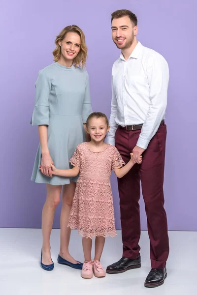 Adorable family with daughter on violet background — Stock Photo