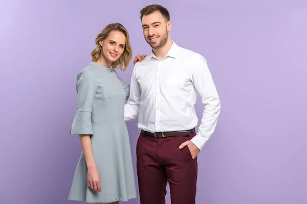 Attractive man and woman posing isolated on violet — Stock Photo