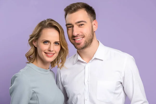 Jovem casal sorridente isolado em violeta — Fotografia de Stock