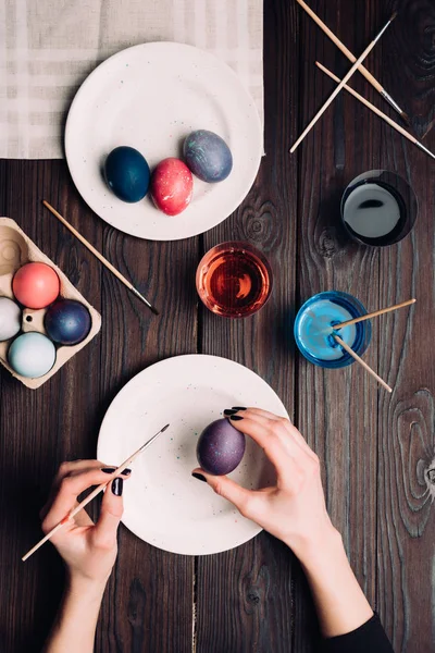 Femme coloriage traditionnel oeuf de Pâques sur assiette — Photo de stock