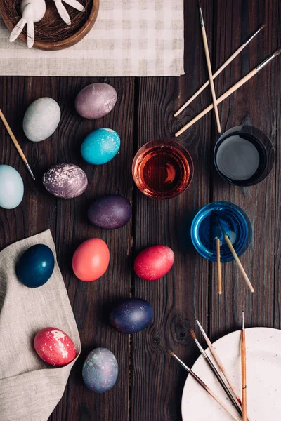 Œufs de Pâques et peinture sur table en bois — Photo de stock