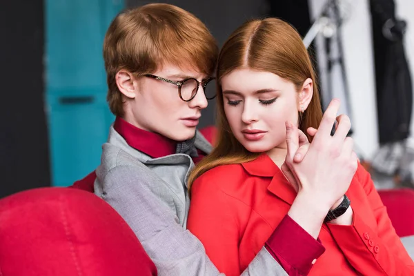 Jeune mannequin masculin en lunettes tenant la main de la petite amie — Photo de stock