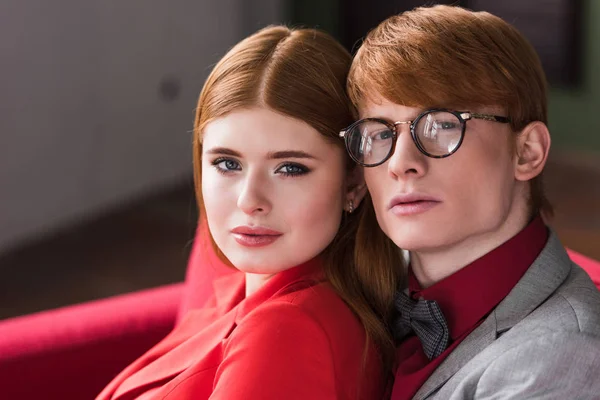 Portrait of young stylish couple sitting on couch — Stock Photo