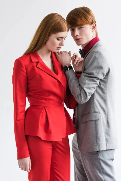 Jovem modelo de moda masculina com relógio de pulso segurando a mão no ombro namorada isolado no cinza — Fotografia de Stock