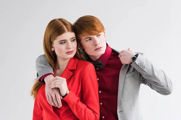 Pareja joven de modelos de moda con relojes de pulsera aislados en gris - foto de stock