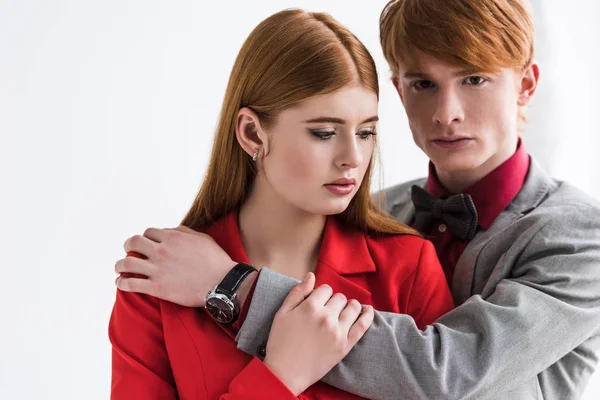 Young male fashion model with wristwatch holding girlfriend shoulder isolated on grey — Stock Photo