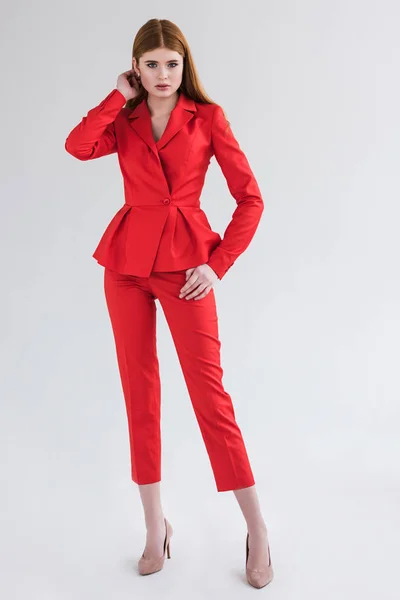 Modella femminile vestita in abito formale rosso isolato su grigio — Foto stock