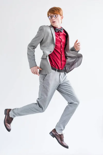 Стрибки чоловічої моделі моди в костюмі ізольовані на сірому — стокове фото