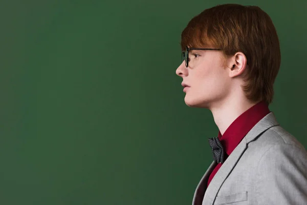 Side view of male fashion model in eyeglasses isolated on green — Stock Photo