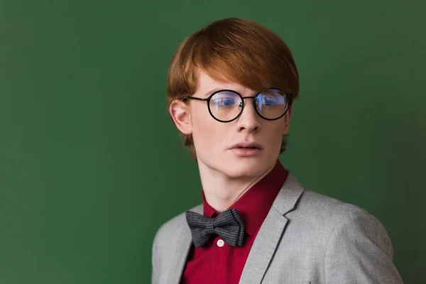 Giovane modello di moda maschile in occhiali isolati su verde — Foto stock