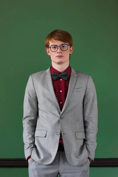 Young male fashion model in eyeglasses dressed in suit — Stock Photo