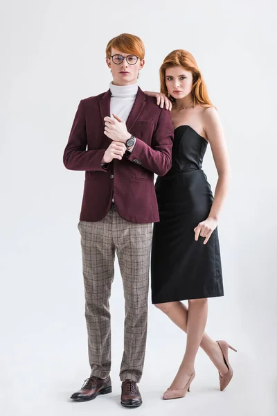 Modelo de moda masculino ajustando el reloj de pulsera mientras que la joven hembra de pie al lado aislado en gris - foto de stock