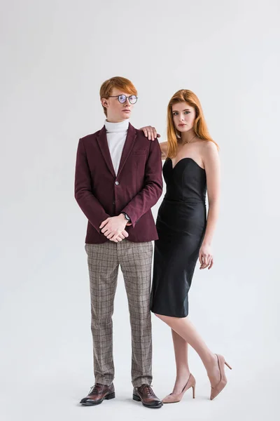 Jeune couple de mannequins habillés en tenue formelle isolé sur gris — Photo de stock