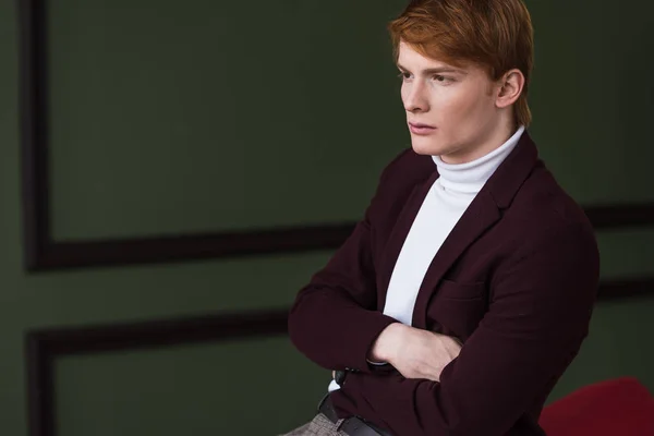 Вид сбоку на мужскую модель в куртке, сидящую на диване — стоковое фото