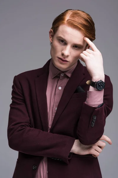 Молодой мужчина модель с наручными часами держа палец на лбу изолированы на сером — стоковое фото