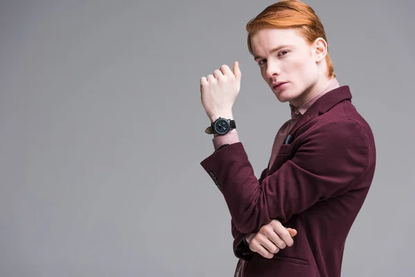 Young male fashion model with wristwach isolated on grey — Stock Photo